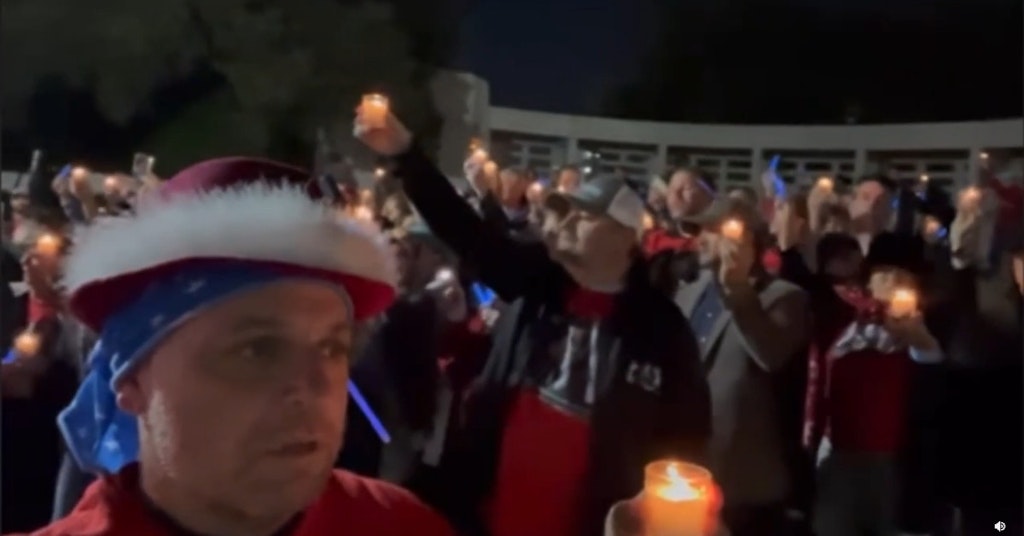 QAnon believers in Dallas holding candles and singing