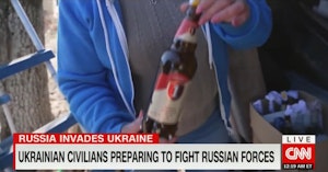 Ukrainian woman holding up a Molotov cocktail for the camera on a CNN report