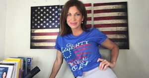 DeAnna Lorraine posing in front of an American flag poster